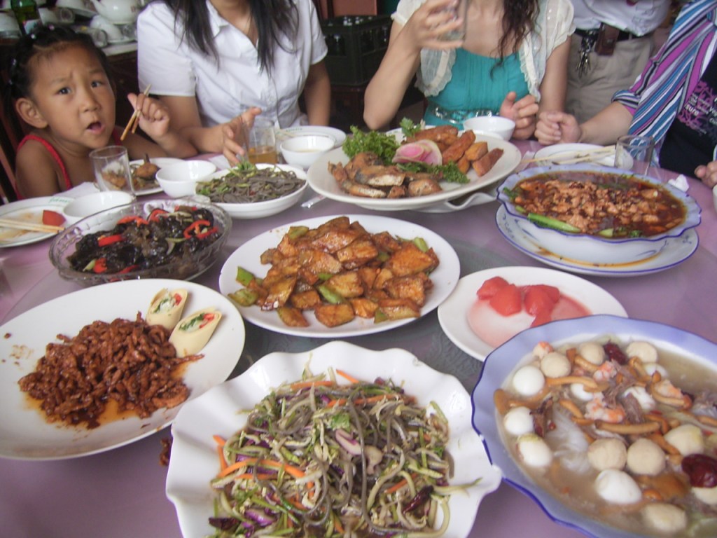 Clockwise from 6:Fern-root noodles and shredded vegetable salad, Shredded pork in 'Capital' (Beijing-style) sauce, Wood-ear salad, Fern-root noodles Hunan style (VERY hot), Fried fish, Shuizhu (water-boiled) meat, Melon, Fish-balls with shrimp and mushrooms, and in the centre Fried potato and green pepper.